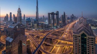 Dubai şehir merkezi silueti en yüksek gökdelenler ve karayolu kavşak gece gündüz timelapse üzerinde en yoğun trafik ile