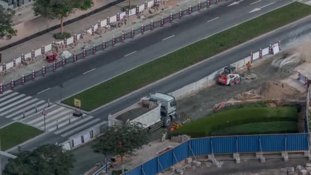 Excavator, truck and grader working at road construction site in Dubai downtown timelapse — Stock Video