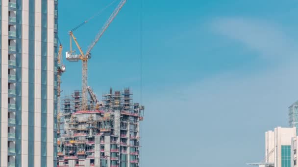 Widok z lotu ptaka wieżowca w budowie z ogromnymi żurawi w Dubaju timelapse. Zjednoczone Emiraty Arabskie — Wideo stockowe