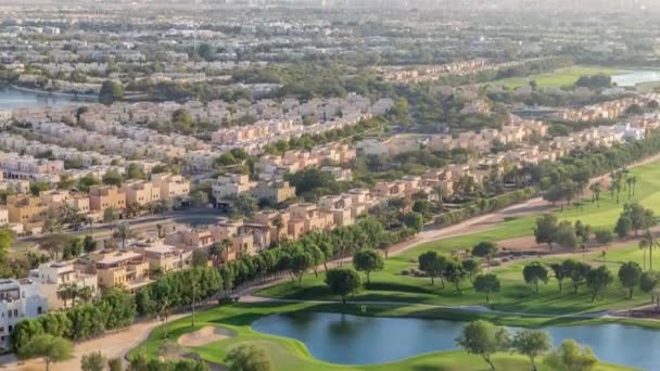 Letecký pohled na vily a domy s golfovým hřištěm se zeleným trávníkem a jezery — Stock video