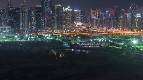 Jumeirah Lake Towers och Dubai Marina skyskrapor och golfbana Night Timelapse, Dubai, Förenade Arabemiraten — Stockvideo