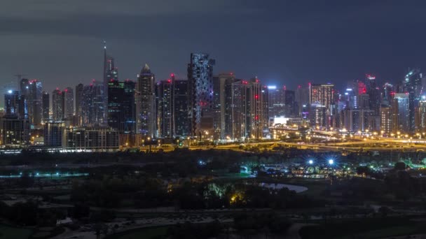 Jumeirah věže a Dubaje Marina mrakodrapy a golfové hřiště po celou noc, v Dubaji, Spojených arabských emirátech — Stock video