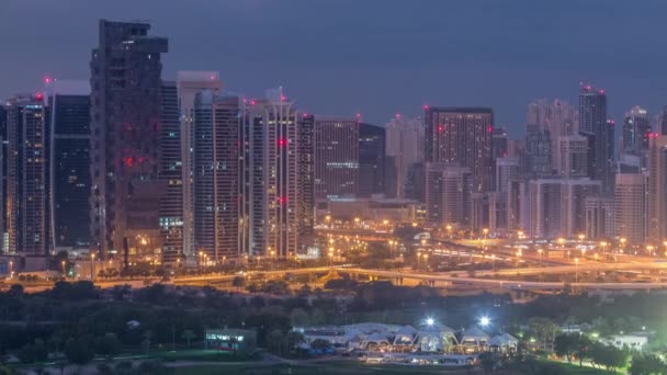 Wieże Jumeirah Lake i Dubai Marina wieżowce i pole golfowe Night to Day timelapse, Dubaj, Zjednoczone Emiraty Arabskie — Wideo stockowe