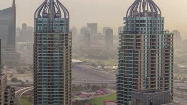 Dubai Marina sabah timelapse havadan üst görünümü. Modern kuleler ve yolda trafik