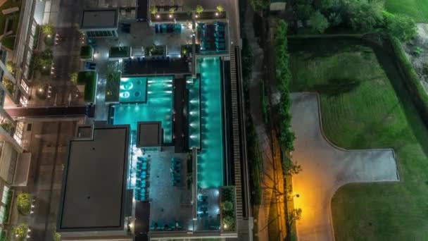 Piscina moderna vista aérea noite timelapse de cima ao lado de um campo de golfe gramado verde — Vídeo de Stock