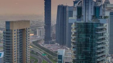Dubai Marina timelapse gündoğumu havadan üst görünümü. Modern kuleler ve yolda trafik