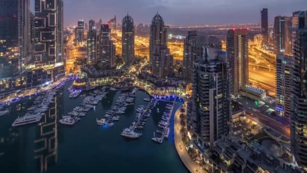 Widok z lotu ptaka Dubai Marina nocy do dnia timelapse. Nowoczesne wieże i ruch na drodze — Wideo stockowe