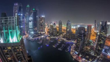 Dubai Marina gece timelapse havadan üst görünümü. Modern kuleler ve yolda trafik