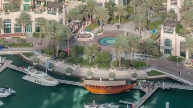 Dubai marina timelapse yüzen yatlar üzerinde havadan görünümü. Beyaz tekneler yeşil kanal suyunda.