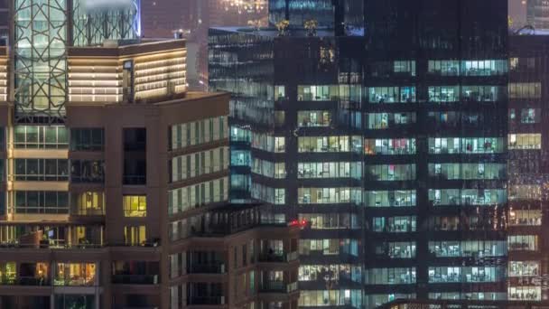 Luces en ventanas del moderno edificio de oficinas de varios pisos en un entorno urbano durante la noche timelapse — Vídeos de Stock