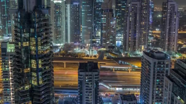 Vista aérea superior do Dubai Marina noite timelapse. Torres modernas e tráfego na estrada — Vídeo de Stock