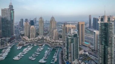 Dubai Marina'nın havadan üstten gündüz gece ye doğru görünümü. Modern kuleler ve yolda trafik