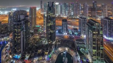 Dubai Marina gece timelapse havadan üst görünümü. Modern kuleler ve yolda trafik