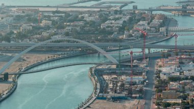 Downtown gökdelenler çatıdan gün batımı hava timelapse sırasında yaya köprüsü ile Dubai su kanalı