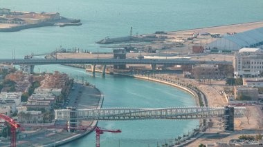 Downtown gökdelenler çatıdan gün batımı hava timelapse sırasında yaya köprüsü ile Dubai su kanalı