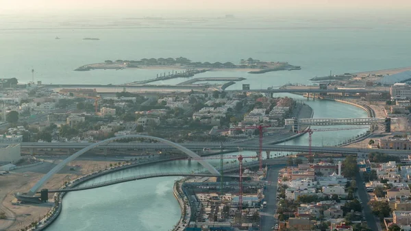 Dubai water canal with footbridge during sunset aerial timelapse from Downtown skyscrapers rooftop