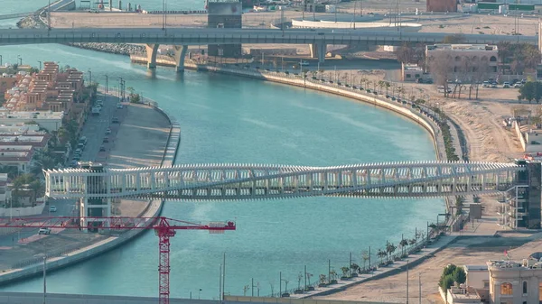 Dubai water canal with footbridge during sunset aerial timelapse from Downtown skyscrapers rooftop