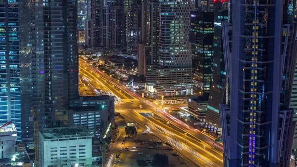Vista aérea de torres em Business Bay com tráfego na estrada noite timelapse . — Fotografia de Stock