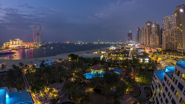 Légifelvétel a strand és a turisták a JBR séta a felhőkarcolók napról-napra az éjszakai TimeLapse Dubai, UAE — Stock Fotó