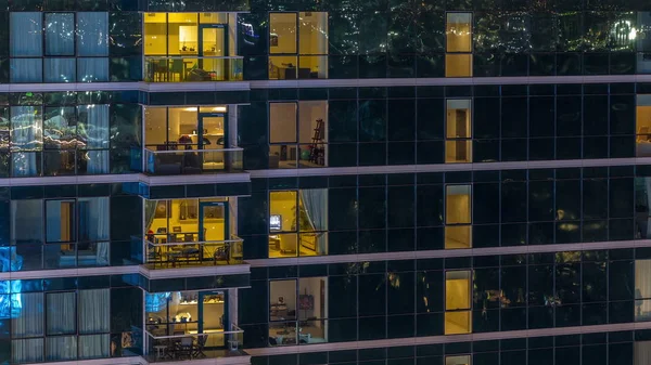 Ventanas de apartamentos brillantes por la noche en rascacielos de cristal timelapse —  Fotos de Stock