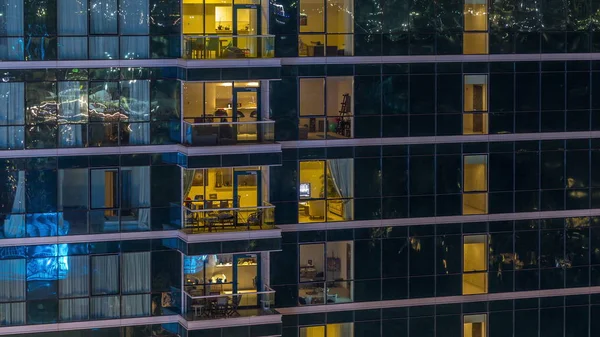 Ventanas de apartamentos brillantes por la noche en rascacielos de cristal timelapse —  Fotos de Stock