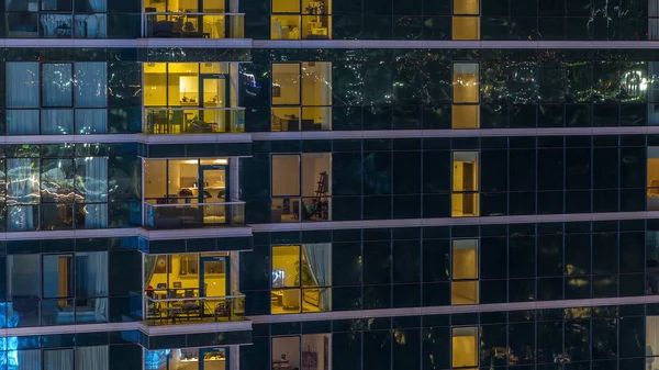 Ventanas de apartamentos brillantes por la noche en rascacielos de cristal timelapse —  Fotos de Stock