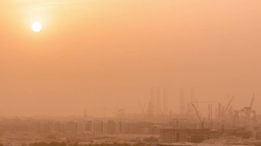 Dubai timelapse sanayi limanı üzerinde kum fırtınası sırasında gün batımı.