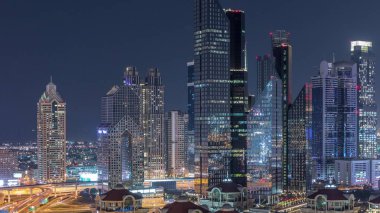 Dubai timelapse ışıklı gökdelenler ve yol kavşağı havadan görünümü