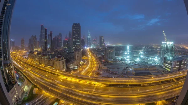 Dubaï skyline nuit au jour le jour timelapse aérien avec la circulation sur l'autoroute — Photo