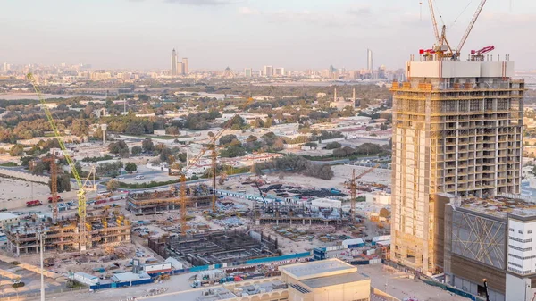 Construction activity in Dubai downtown with cranes and workers timelapse, UAE.