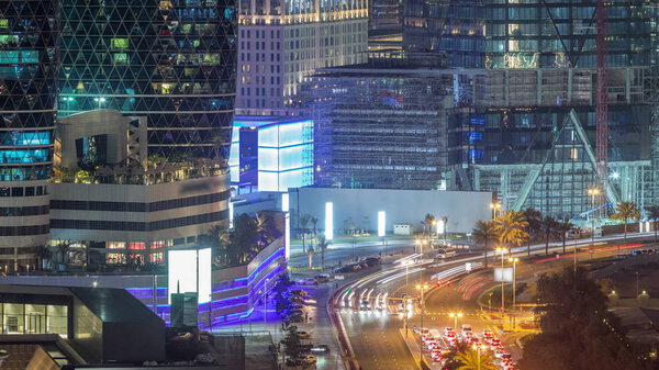 Skyline view of intersection traffic on Al Saada street near DIFC night timelapse in Dubai, UAE. Illuminated skyscrapers in financial centre aerial view from above in downtown