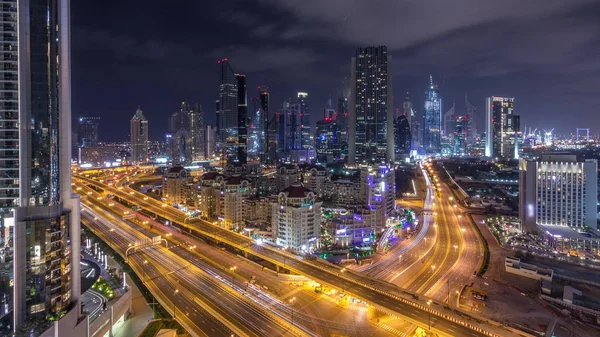 Vista aérea no centro da cidade e distrito financeiro em Dubai durante toda a noite timelapse, Emirados Árabes Unidos com arranha-céus e rodovias . — Fotografia de Stock