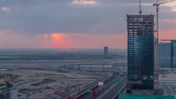 Salida del sol vista aérea del centro financiero carretera mañana timelapse con edificio en construcción —  Fotos de Stock