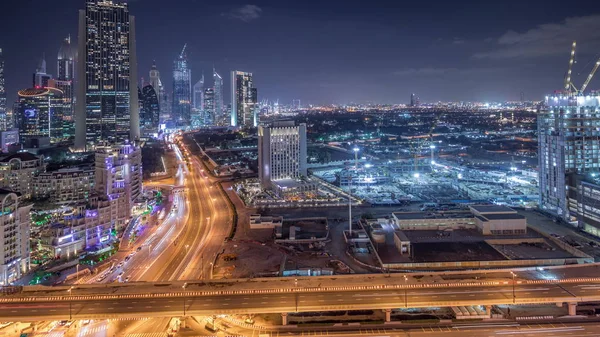 Atividade de construção no centro de Dubai com guindastes e trabalhadores noite timelapse, Emirados Árabes Unidos . — Fotografia de Stock