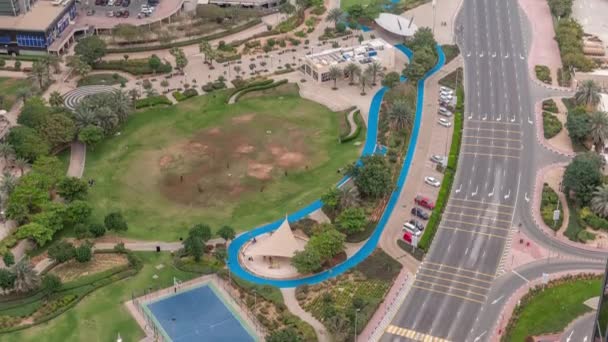 Ein landschaftlich gestalteter öffentlicher park in jumeirah seen türmt sich im zeitraffer auf, ein beliebtes wohnviertel in dubai. — Stockvideo