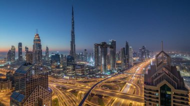 Dubai şehir merkezi silueti en yüksek gökdelenler ve karayolu kavşak gece gündüz timelapse üzerinde en yoğun trafik ile