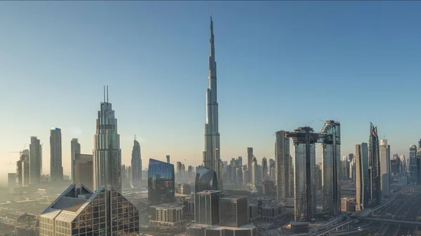 Dubai Downtown skyline met de hoogste wolkenkrabbers en drukste verkeer op snelweg kruising nacht tot dag timelapse — Stockfoto