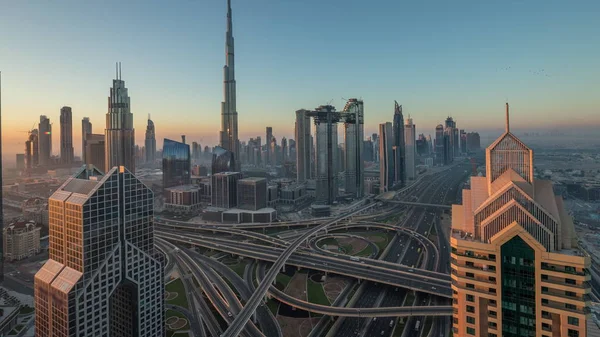 Dubai downtown skyline with tallest skyscrapers and busiest traffic on highway intersection night to day timelapse — Stock Photo, Image