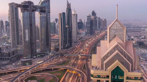 Dubai downtown skyline with tallest skyscrapers and busiest traffic on highway intersection night to day timelapse — Stock Photo, Image