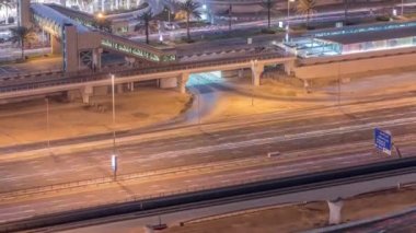 Dubai, Bae Dubai Marina gece timelapse tramvay durağından footbridge ile alışveriş merkezi yakınında trafik havadan üst görünümü.
