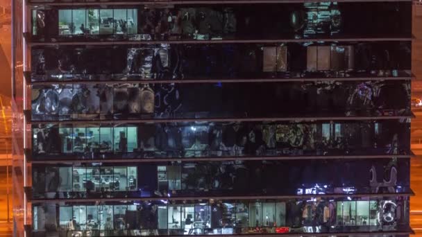 Escritório arranha-céus exterior durante o final da noite com luzes interiores acesas e pessoas que trabalham dentro da noite timelapse — Vídeo de Stock