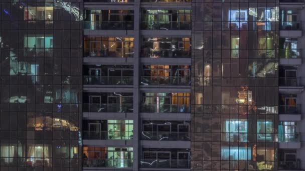 Éjszakai kilátás a külső lakás épület TimeLapse. Magas emelkedik a felhőkarcoló, villogó fények a Windows — Stock videók