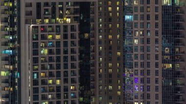 Çok katlı binanın içinde aydınlatma ve apartmanlarda zaman atlamalı insanları hareket ettiren pencereler.