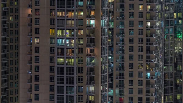 Janelas do edifício de vários andares com iluminação interior e pessoas em movimento em apartamentos timelapse . — Fotografia de Stock