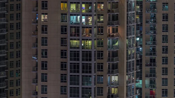 Ramen van het gebouw met meerdere verdiepingen met verlichting binnen en bewegende mensen in appartementen timelapse. — Stockfoto