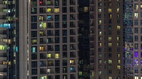 Ventanas del edificio de varios pisos con iluminación interior y personas en movimiento en apartamentos timelapse . —  Fotos de Stock