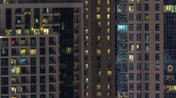 Ventanas del edificio de varios pisos con iluminación interior y personas en movimiento en apartamentos timelapse . — Foto de Stock