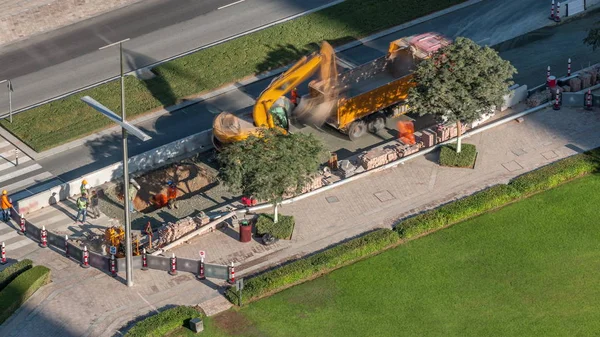 ドバイのダウンタウンタイムラプスの道路建設現場で働く掘削機とトラック — ストック写真