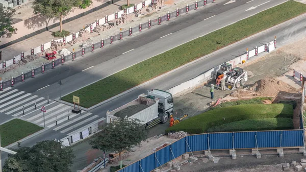 Excavadora, camión y niveladora trabajando en el sitio de construcción de carreteras en el centro de Dubai timelapse — Foto de Stock