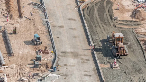 ドバイのダウンタウンタイムラプスの道路建設現場で働く掘削機、トラック、グレーダー — ストック写真